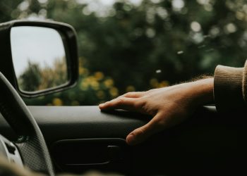 a person's hand on the steering wheel of a car