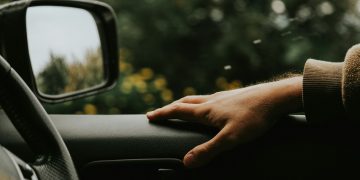 a person's hand on the steering wheel of a car