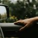 a person's hand on the steering wheel of a car