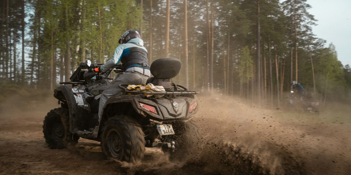 a person riding an atv on a dirt road