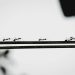 a group of ants standing on top of a metal bar