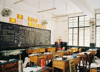 a classroom filled with desks and a chalkboard