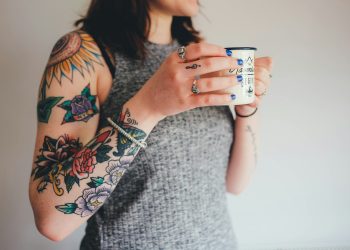 woman holding white ceramic mug