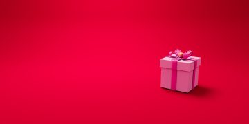 a pink gift box with a bow on a red background